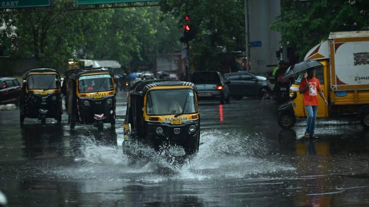 Mumbai auto-rickshaws navigating flooded waterlogged streets during heavy monsoon rain