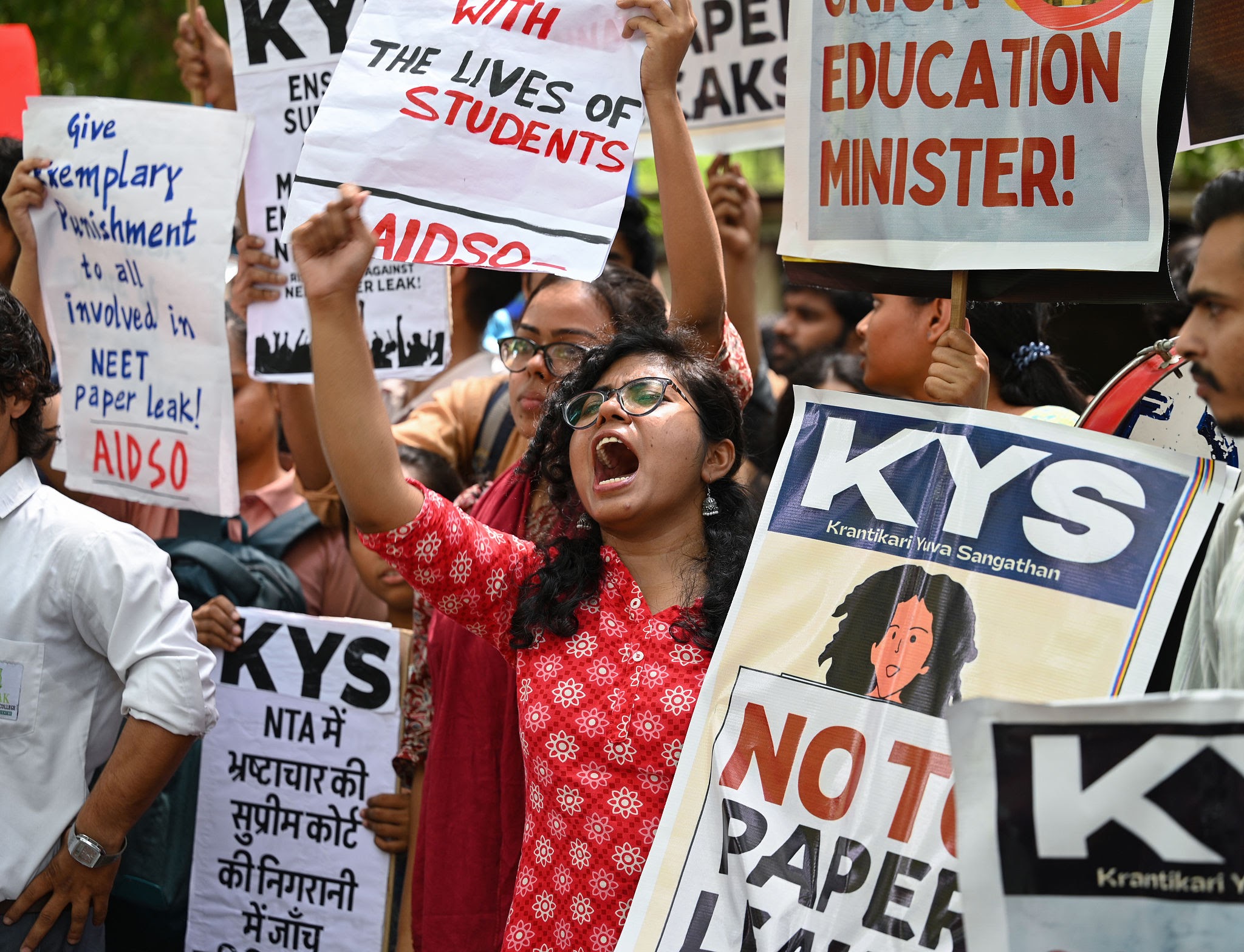 Student protesters holding placards demanding NEET paper leak inquiry and Education Minister resignation