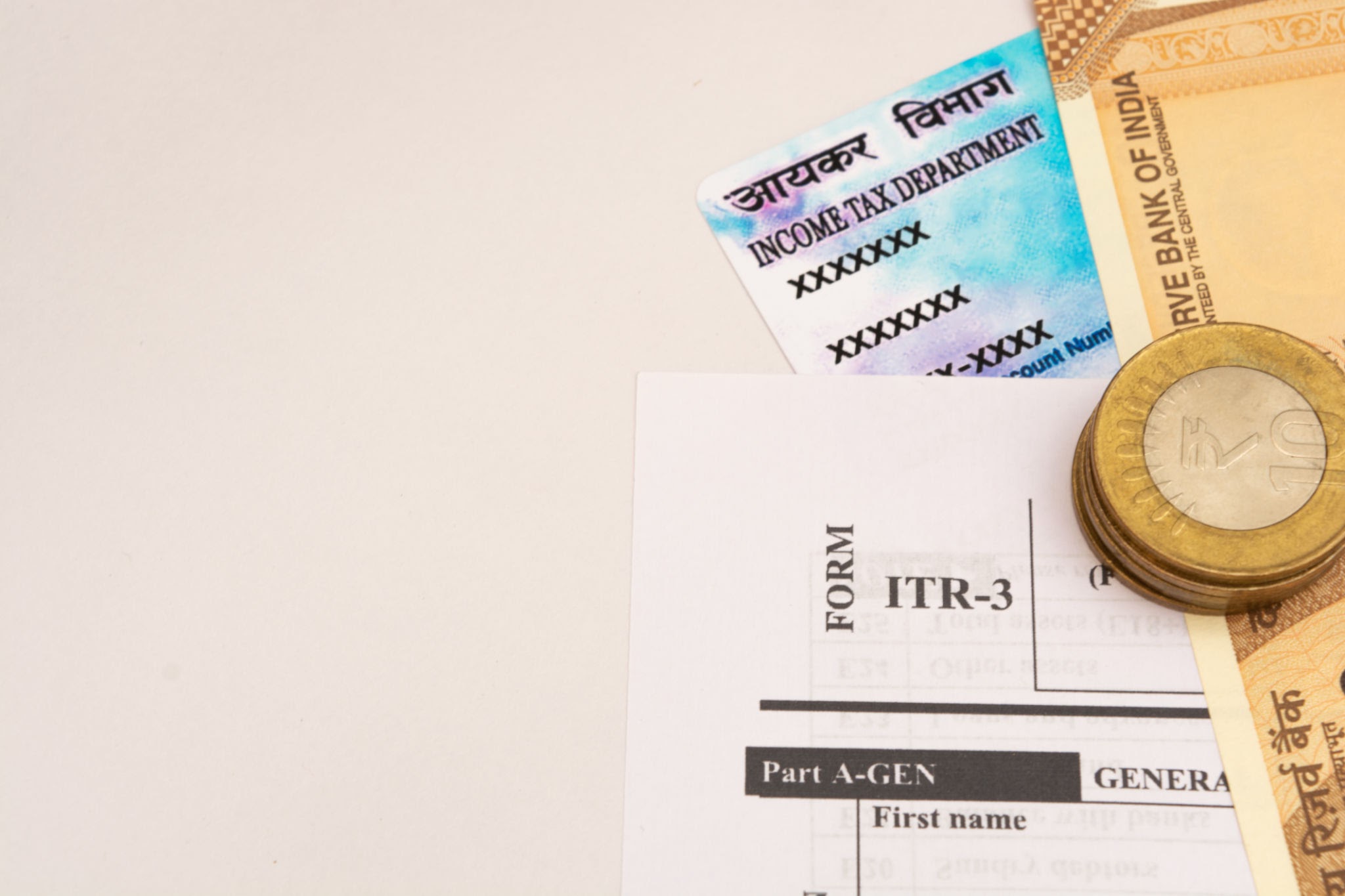 PAN Card of Income Tax Department with Indian Rupee notes and ITR form