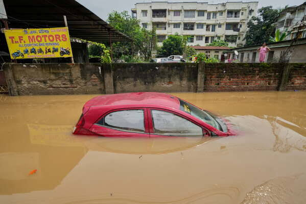 NDRF personnel conducting flood rescue operations using inflatable boat in inundated area