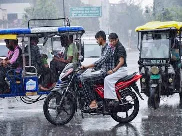 Commuters navigating waterlogged roads during heavy monsoon rains in a city