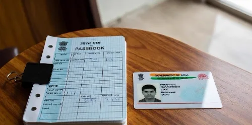 Aadhaar card and bank passbook representing Aadhaar-seeded Direct Benefit Transfer