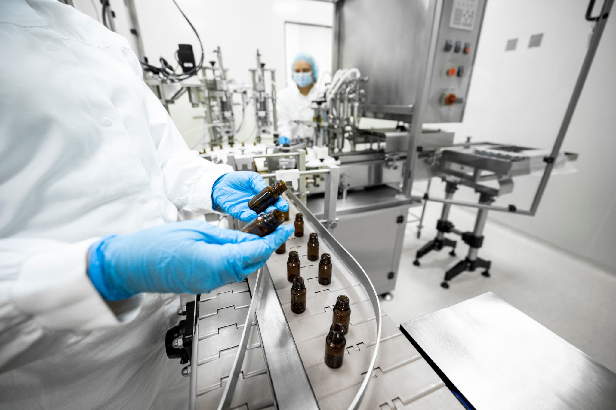Conveyor belt transporting amber glass medicine vials in a sterile cleanroom