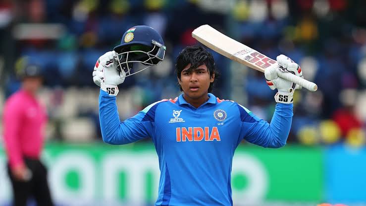 15-year-old Vaibhav Suryavanshi raising bat and helmet celebrating half-century